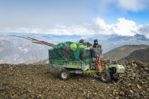 Ein Einachsschlepper mit Anhänger ladet Holz, Arbeitsgeräte und Rucksäcke in Peru in den Anden bei 4000 Metern über dem Meeresspiegel